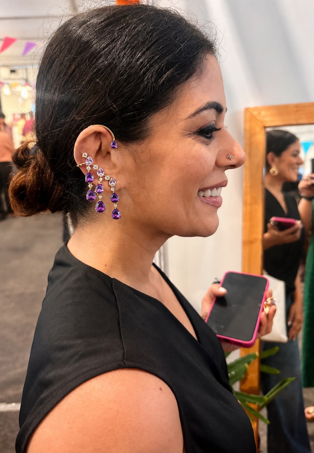 Model wearing Cosmic gold-plated earcuffs with cascading colourful AD stone drops in lifestyle setting