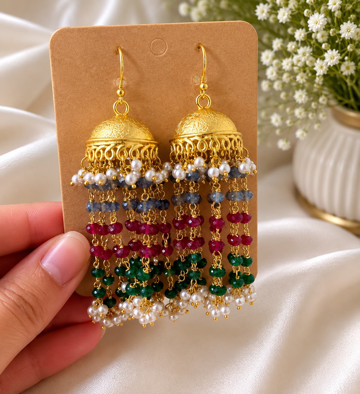 Festive jhumka earrings in gold-plated brass with ornate dome, cascading synthetic pearls and colourful beads