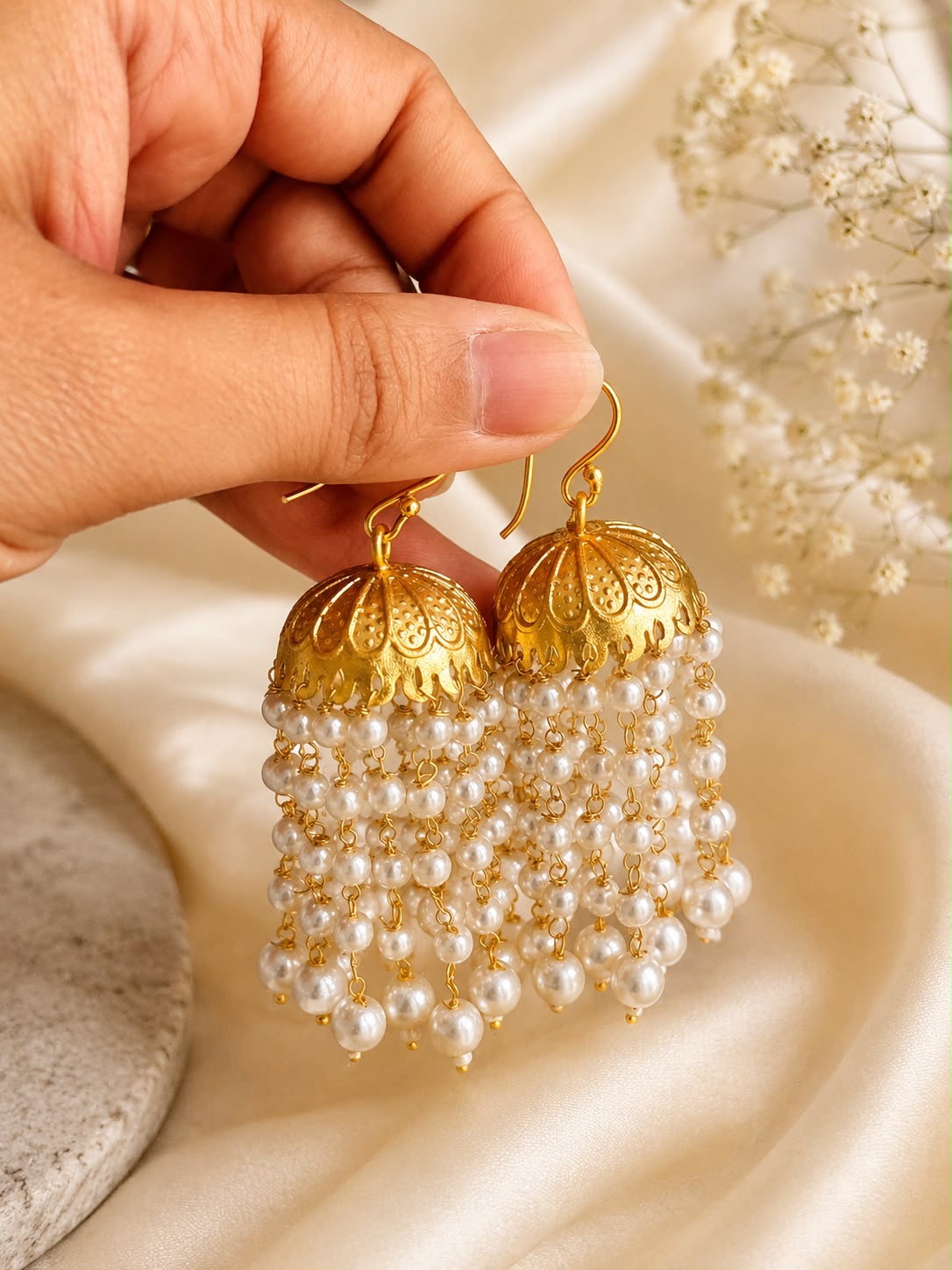 Pearl Muthukuda traditional jhumka earrings in gold-plated brass with cascading synthetic pearl bead strings