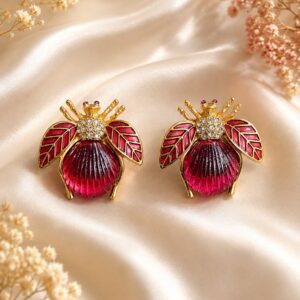 The Ruby Bug bee-inspired stud earrings in 18K gold plating with ruby-toned resin centre