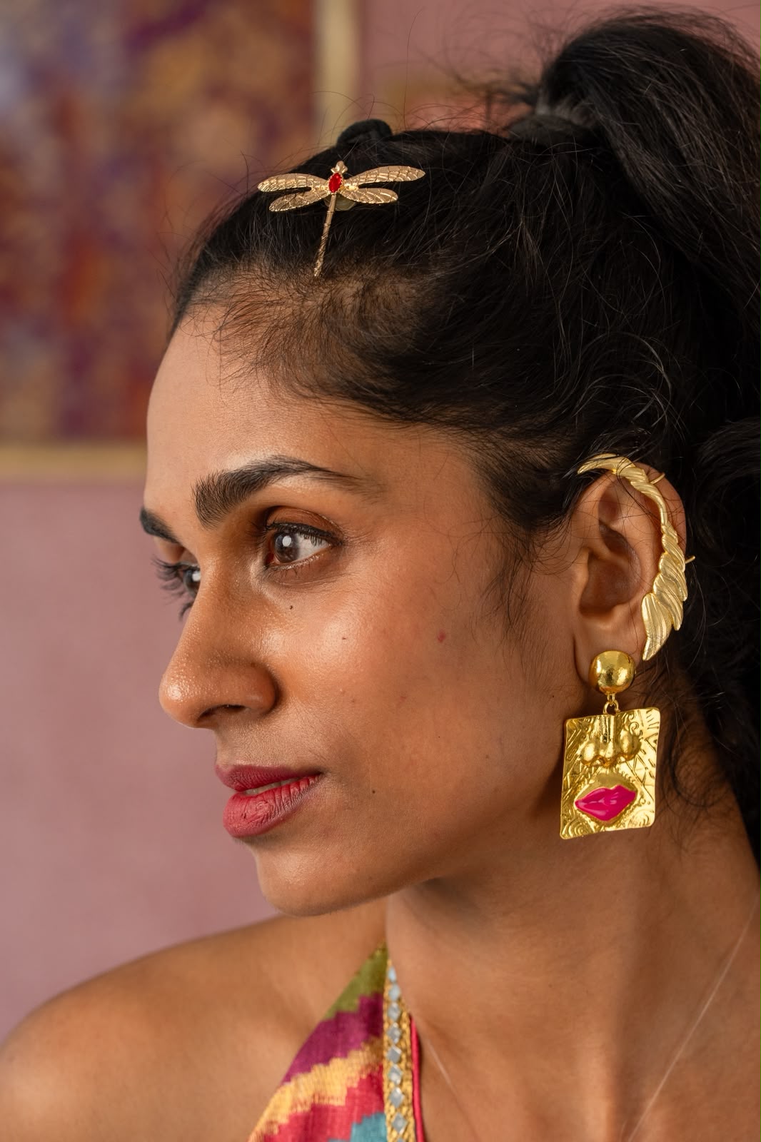 Close-up of model wearing Ju-el Pop Concept square gold-tone drop earring with pink lips accent